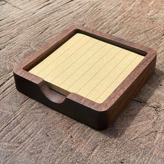 a small wooden box with writing paper in it on a wood table top or floor