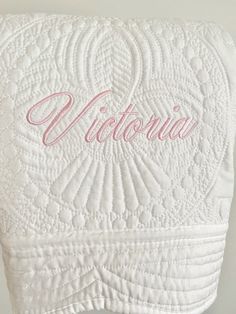 a white towel with the word victoria on it and pink lettering in cursive font