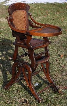 an old wooden high chair sitting in the grass