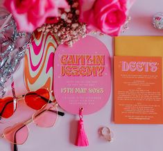 pink flowers and sunglasses are on the table next to an orange card that says, captain jerry