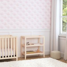 a baby's room with pink and white wallpaper