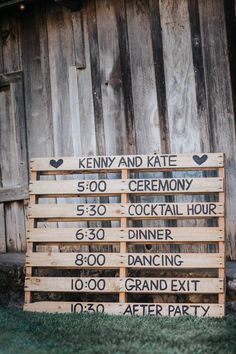 a wooden sign sitting in front of a barn