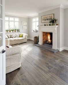 a living room filled with furniture and a fire place in the middle of the room