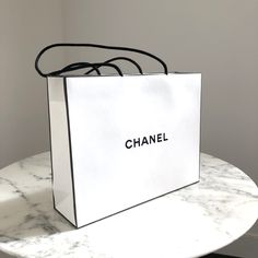 100% Authentic Chanel Gift Bag. New. Never Used. Gorgeous Iconic White Bag With Black Trim And "Chanel" Logo Printed On Both Sides. Approximate Measurements: 10” X 7.75” X 3” Inch. Chanel Gift Bag, Chanel Shopping, Chanel Party, Chanel Black And White, Chanel Logo, Black Trim, White Bag, House Party, Luxury Designer