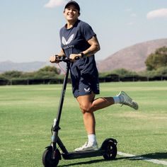 a woman is riding an electric scooter on the grass