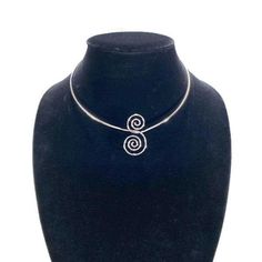 With its timeless style and high quality craftmanship, this vintage choker from AVON is sure to become a favorite piece in your jewelry collection. Circa 1978. Crafted with silver plated metal in a unique spun swirls design. A hook closure keeps it secure when worn. The choker measurement is 16" inches long and the Swirl Pendant is 1 1/2" inches by 7/8" inches wide. TO VIEW MORE FROM NEW VINTAGE FOR YOU, GO HERE: https://newvintageforyou.etsy.com Please note: All vintage items are sold as is in Vintage Silver Beaded Choker, Vintage Silver Choker As Gift, Vintage Silver Choker For Gift, Elegant Silver Spiral Jewelry, Silver Spiral Jewelry For Party, Elegant Silver Spiral Necklace, Silver Spiral Metal Necklaces, Nickel-free Silver Choker, Silver Spiral Metal Necklace