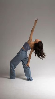 a woman is standing in the air with her arms up and legs spread wide out