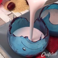 a blue bowl filled with milk and strawberries