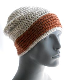 a mannequin head wearing a crocheted hat with an orange and white stripe