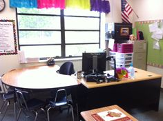 an office with desks and chairs in front of a window