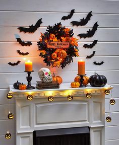 a fireplace decorated for halloween with pumpkins and candles