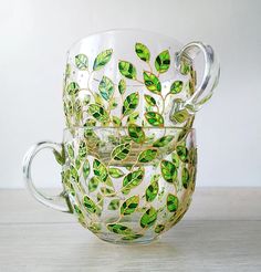 two glass cups with green leaves painted on them