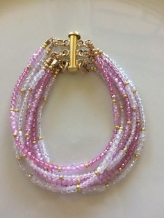 This is a multi strand bracelet with clasp. the stones are pink topaz, pink zirconia and white zirconia with tiny little gold fill beads. There are 7 strands and the components are gold filled but the clasp is gold plated. This measures just under 6 inches. ABOUT SHIPPING- Shipping within Canada is crazy expensive. If there is any overage I will refund. I'm very limited in adding different cost of shipping between provinces. I have tried different ways of listing shipping costs and this is the o Pink Multi-strand Faceted Beads Jewelry, Pink Multi-strand Jewelry With Faceted Beads, Pink Multi-strand Beaded Bracelets, Multi Strand Bracelet, Waist Beads, Pink Topaz, Beads Bracelets, Bracelets Diy, Pink Jewelry