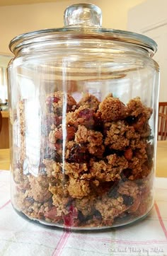 a glass jar filled with granola sitting on top of a table