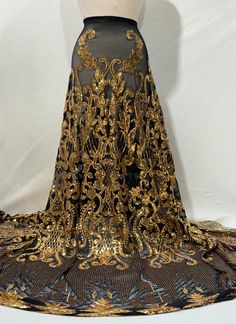 a black and gold dress on display next to a mannequin