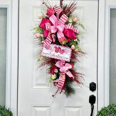 a pink wreath on the front door of a house