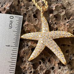 Get noticed with this sparkling 18K Gold Filled Large Star Fish Pendant. Each cubic zirconia is individually mounted to create an organic textured look with incredible shine. Each tip of the Star Fish has a polished finish further accenting the design. Includes 18K Gold Filled 3mm width, extra long 24 inch length Chain. 18K Gold Filled Star Fish Pendant Cubic Zirconia individually mounted Incredible shine and sparkle Polished tips accent the design Includes 18K Gold Filled 3mm width, extra long Gold Star Jewelry With Sparkling Stones, Star Shaped Cubic Zirconia Jewelry With Sparkling Stones, Gold Star-shaped Jewelry With Diamond Cut, Gold Star-shaped Diamond Cut Jewelry, Gold Sparkling Star Jewelry, Cubic Zirconia Star Jewelry With Sparkling Stones, Gold Star-shaped Sparkling Jewelry, Gold Star-shaped Jewelry With Sparkling Stones, Sparkling Gold Star-shaped Jewelry