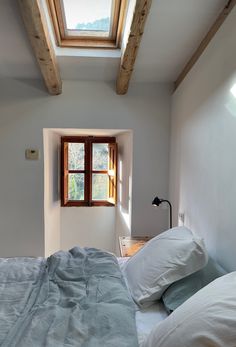 a bed sitting under a window in a bedroom