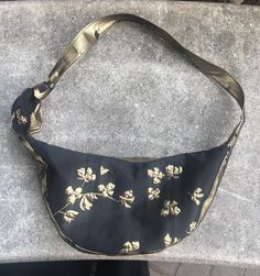 a black purse with gold flowers on it