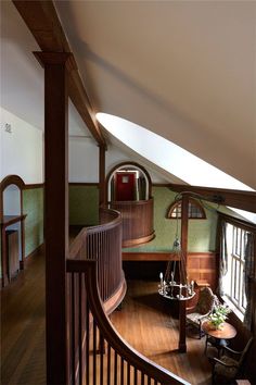 the interior of a house with wood floors and green wallpaper on the walls, along with wooden railings