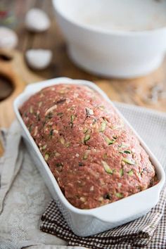 a loaf of bread sitting on top of a table next to a bowl and spoon