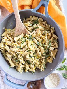 a pan filled with pasta and vegetables on top of a table