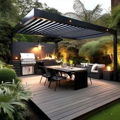 an outdoor kitchen and dining area is lit up at night with lights on the table