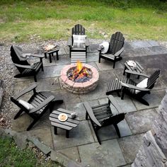 an outdoor fire pit with chairs around it