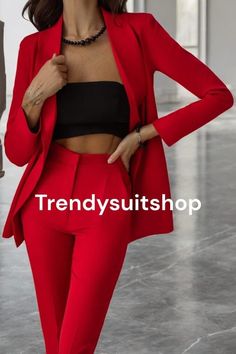 a woman in a red suit and black top posing for the camera with her hands on her hips