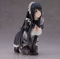 an anime figurine sitting on the ground with long black hair and green eyes