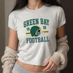 Elevate your game day style with our Green Bay Football Ladies Crop Top! Designed for true fans who want to showcase their team spirit, this trendy football crop top or football baby tee combines comfort and flair. This youth-size t-shirt is designed to acheive the classic '90s baby tee look. This is the Gildan 5000b youth tshirt. Please refer to size charts in the pictures for sizing information. Featuring the iconic Green Bay colors and a catchy design front and center, this crop top sports vibrant green and gold colors that make a bold statement. The stylish cut looks great paired with high-waisted jeans, shorts, or leggings. Make a fashion statement with this football game outfit or tailgate shirt! Whether you're tailgating, attending a game, or just showing off your Greenbay pride, th Cheap Green Tops For Football Season, Football Wife Shirt, Tailgate Shirt, Football Game Outfit, Football Baby, Football Outfits, Gameday Outfit, Gaming Clothes, Green Bay