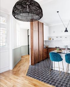 a kitchen with wooden floors and blue chairs