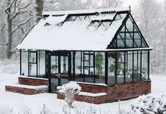 a small house covered in snow with lots of windows on the front and side of it