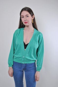 Add a touch of vintage charm to your wardrobe with this green minimalist buttons cardigan! Made from comfortable cotton, this cardigan features a unique design that is perfect for adding a retro flair to your outfit. Please note that this is a vintage item, so it may have some defects. To ensure a proper fit, please refer to the measurements below: Sleeve: 46cm / 18.11 inches (measured from armpit to end of sleeve) Width: 52cm / 20.47 inches Length: 52cm / 20.47 inches These measurements are tak Green V-neck Cardigan For Layering, Green V-neck Sweater With Button Closure, Green Cotton Long Sleeve Cardigan, Green V-neck Cardigan With Buttons, Retro Green V-neck Sweater, Vintage V-neck Cardigan For Layering, Green Cotton V-neck Cardigan, Green Cotton Sweater With Button Closure, Green Cotton Cardigan For Fall