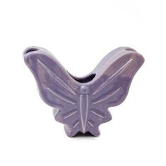 a purple butterfly shaped vase sitting on top of a white table