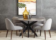 a dining table with four chairs and a vase on the table in front of it