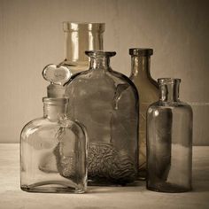 three glass bottles sitting next to each other on a table