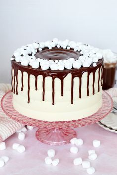 a chocolate cake with marshmallows on top and white frosting drizzled over it