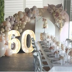 the table is set up with balloons and lights for an elegant 60th birthday party at home