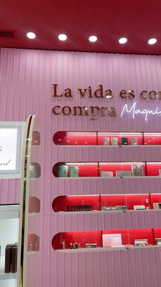 a store front with pink walls and shelves filled with cosmetics on the wall is a sign that says la vida es contemporma magnana