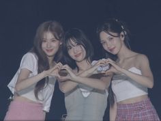 three young women making heart shapes with their hands