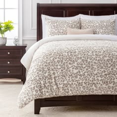 a bed with a white and brown leopard print comforter