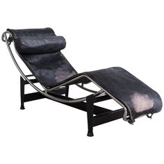 a black leather chaise lounge chair with footstool on an isolated white background