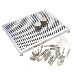 several different sizes and shapes of screws on a white surface with holes in the middle