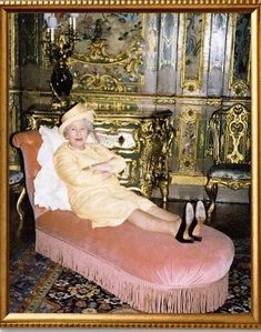 an old photo of a woman sitting on a pink couch