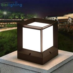 a light that is sitting on top of a cement block with grass in the background