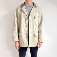 Cool, classy, casual men's vintage jacket in neutral stone beige and brown leather collar. It fastens with hidden buttons, has three front pockets plus one in the inside and is lined with a panel of beautiful plaid. The coat is lightweight, yet fairly sturdy, made from heavy weight canvas with a striped textured weave. It's a smart, neutral wardrobe staple for spring/autumn, to go with smart trousers or jeans. Made in Philippines by St. Michael. Shell: 100% cotton + 100% leather; Lining: 65% pol Classic Beige Collared Blazer, Classic Beige Outerwear With Corduroy Collar, Classic Khaki Outerwear With Patch Pockets, Classic Khaki Outerwear For Everyday, Classic Cream Outerwear With Flap Pockets, Classic Everyday Khaki Outerwear, Vintage Outerwear With Flap Pockets For Everyday, Vintage Everyday Outerwear With Flap Pockets, Vintage Khaki Outerwear With Welt Pockets