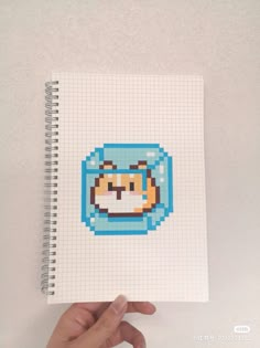 a hand holding up a notebook with an image of a cat in the middle of it