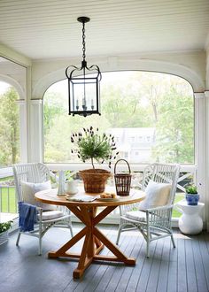 a porch with chairs and a table on it