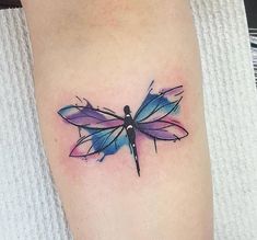 a dragonfly tattoo on the left thigh and right leg is blue with purple wings